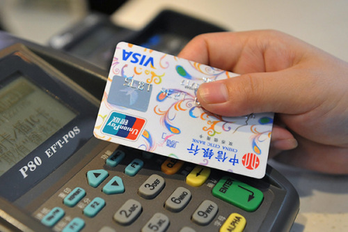 A customer makes a payment with a credit card at the market in Lin'an, Zhejiang province. The total number of credit cards in use was 424 million at the end of the first quarter of the year. (Photo/China Daily)