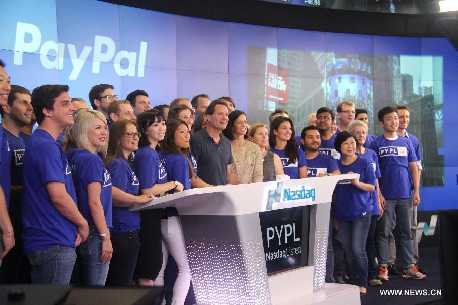 PayPal President and CEO Dan Schulman (C) poses for photos with employees during the company's relisting on the Nasdaq in New York, the United States, July 20, 2015. (Photo: Xinhua/Huang Jihui)