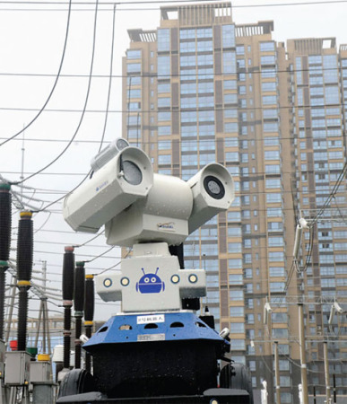 A robot monitors power-transmission equipment during a rainstorm in Chuzhou, Anhui, on Aug 10. (Photo/China Daily)