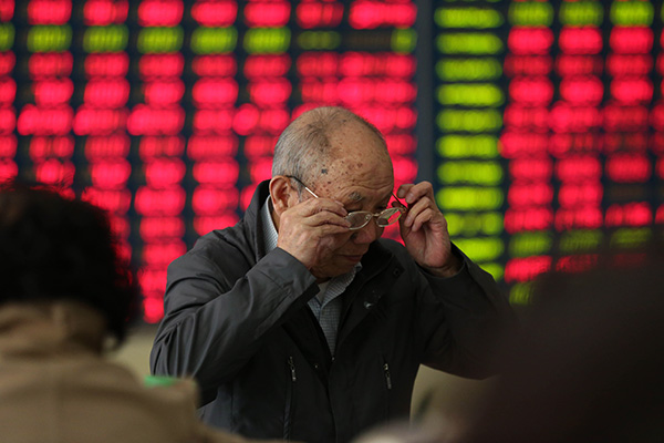 An investor looks at an electronic trading screen at a brokerage in Nantong, Jiangsu province. (Photo/China Daily)