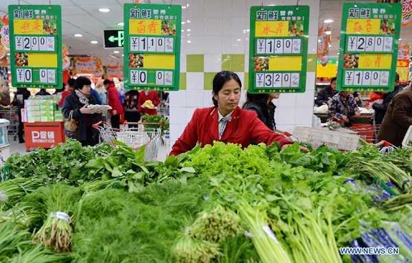 A staff member places vegetables at a super market in Cangzhou, north China's Hebei Province, Nov. 8, 2015. China's consumer price index (CPI), the main gauge of inflation, grew 1.3 percent year on year in October. (Photo: Xinhua/Mo Yu) 