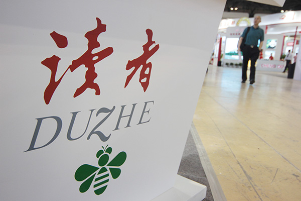 A pedestrian walks past an advertisement for The Duzhe magazine in Beijing, China, May 29, 2014. (Photo/China Daily)