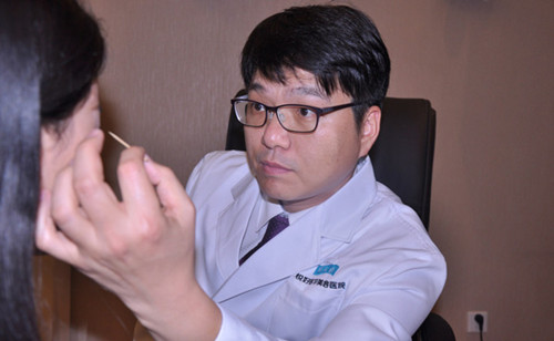 A South Korean doctor checks a beauty seeker's facial condition for a possible cosmetic surgery in Chengdu, capital of Sichuan province. Photo/China Daily