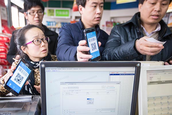 Bargain-hunters flash the Alipay Wallet QR codes on their smartphones at a Hangzhou supermarket checkout to avail 10 percent discount on their shopping.(Photo/China Daily)