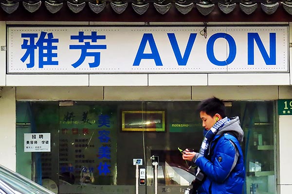 A man walks past an outlet of Avon Products Inc in Shanghai.(Photo: China Daily/Jing Wei)