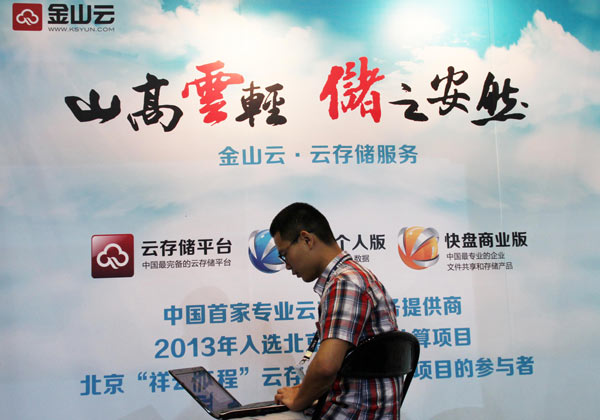 A visitor in front of a Kingsoft Corp Ltd advertisement at a mobile Internet expo in Beijing. The company aims to become the leading player in the fast-growing domestic cloud-computing market.(Photo/China Daily)