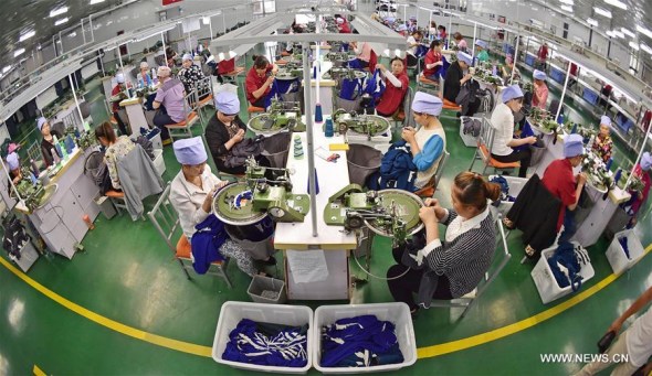 Workers make clothing ta a textile mill in Yinchuan, northwest China's Ningxia Hui Autonomous Region, June 22, 2015. China's economy grew by 6.9 percent in 2015.(Xinhua file photo/Wang Peng)