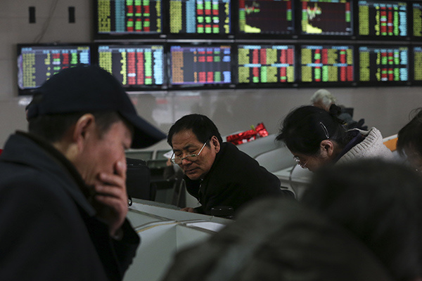 An investor checks stock prices at a securities brokerage in Nantong, Jiangsu province. (Photo/China Daily)