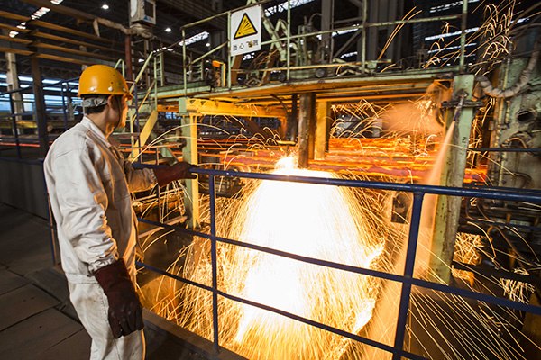 A worker at a steel company in Lianyungang, Jiangsu province, in January 2015. The steel sector will reduce capacity by 100 to 150 million metric tons in five years, according to China's top economic planner. (Photo/China Daily)