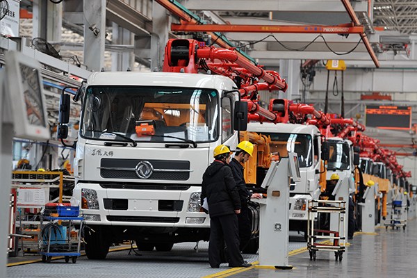 Sany Group technicians assemble engineering machinery in the firm's assembly plant in Changsha, Hunan province. (Photo/Xinhua)