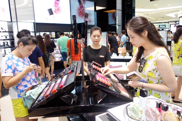 Tourists select cosmetics at Sanya Haitang Bay International Shopping Mall.(Photo by Huang Yiming / China Daily)