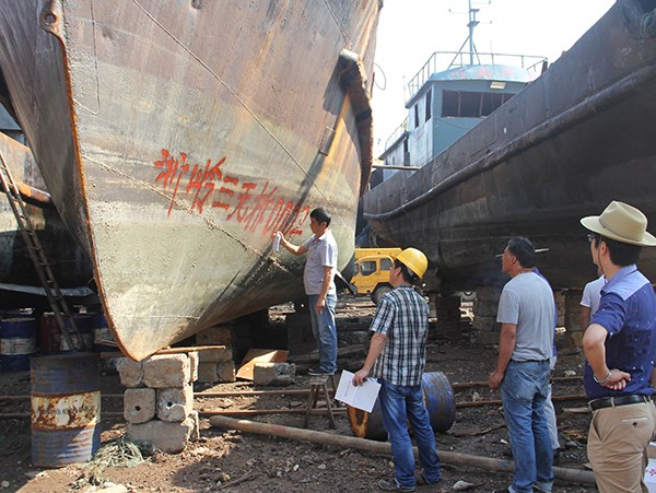 A ship-breaking company's staff workers make marks on a to-be-dismantled ship in Taizhou, Zhejiang province.(Jiang Wenhui/For China Daily)