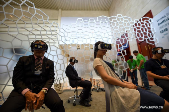 Visitors watch a movie with VR headsets at the exploration zone on the Annual Meeting of the New Champions 2016, or the Summer Davos Forum, in Tianjin, north China, June 26, 2016. (Xinhua/Bai Yu)  