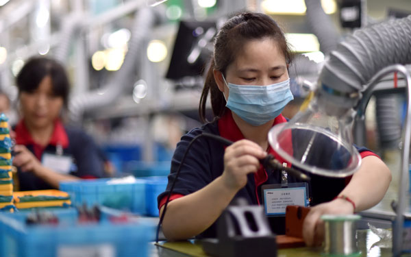 Workers assemble lithium batteries in Huzhou, Zhejiang province. The electric-car industry gives a boost to the battery manufacturing sector. (Photo/China Daily)