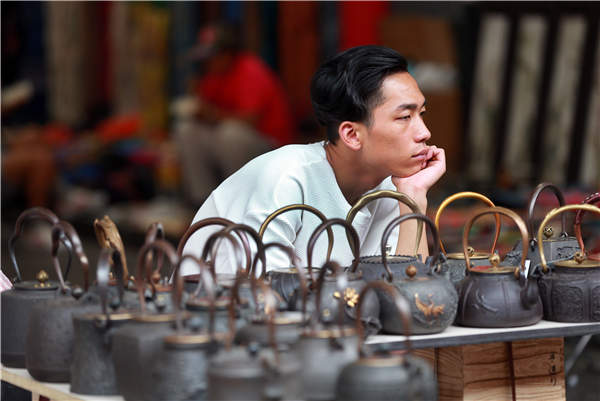 A customerless vendor is in a daze at Panjiayun Antiques Market in Beijing. (Photo by Zou Hong/China Daily)