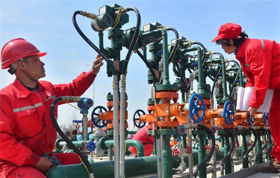 Workers inspect the gas and oil facilities at an oilfield belonging to China Petrochemical Corp in Puyang, Henan province. (TONG JIANG / FOR CHINA DAILY)