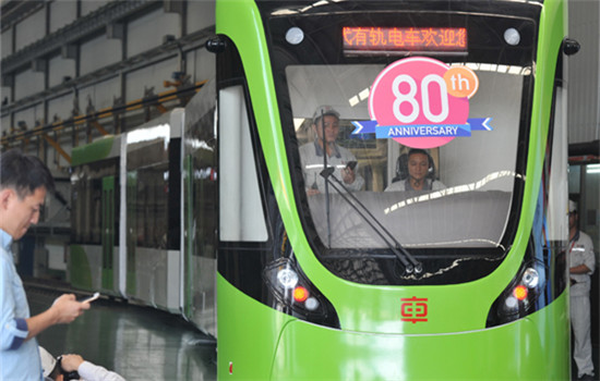 Two engineers conduct a test on a new tram just off the production line at the CRRC Zhuzhou Locomotive Co Ltd. (Long Hongtao / Xinhua)