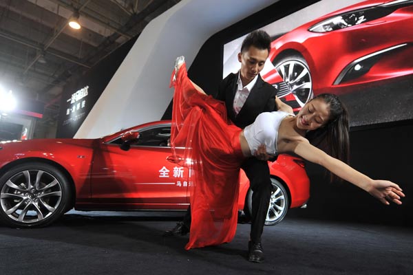 Models perform at an auto show in Qingdao, Shandong province. (Photo by Wang Haibin/For China Daily)