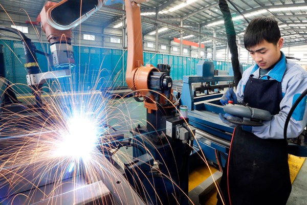 A skilled worker operates a welding robot at an elevator-manufacturing company in Lianyungang, Jiangsu province. SI WEI / FOR CHINA DAILY