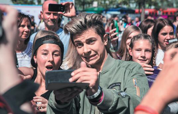 An online celebrity from Muscial.ly poses for selfies with a group of fans at Local Video Day in Berlin in August 2016. (Photo provided to China Daily)