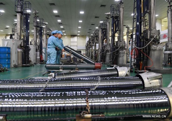 Photo taken on Feb. 24, 2017 shows workers carrying a monocrystalline silicon stick at a factory in Ningjin County, north China's Hebei Province.(Xinhua/Mu Yu)