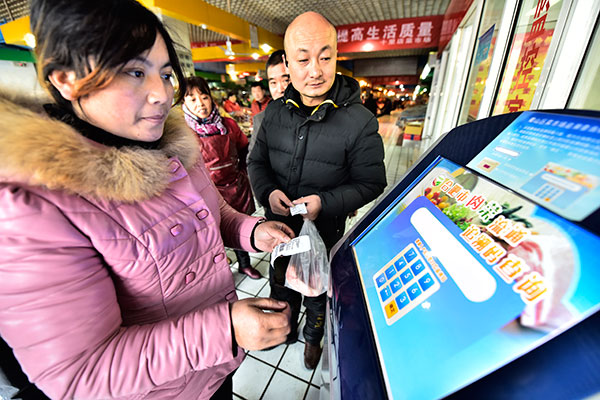 A customer traces the origin of her products at a market in Hefei, capital of Anhui province, in January. (Photo/China Daily)