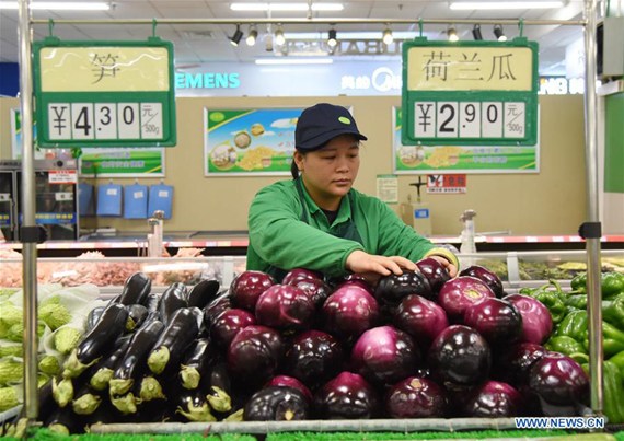 A saleswoman arranges vegetables at a supermarket in Hejian City, north China's Hebei Province, April 12, 2017. China's consumer price index (CPI), a main gauge of inflation, grew 0.9 percent year on year in March, the National Bureau of Statistics announced on April 12. (Xinhua/Zhu Xudong)