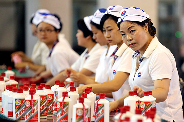 Workers pack bottles of liquor at the Kweichow Moutai Co Ltd plant in Maotai, a town in southwestern China's Guizhou province. (JIANG DONG/CHINA DAILY)