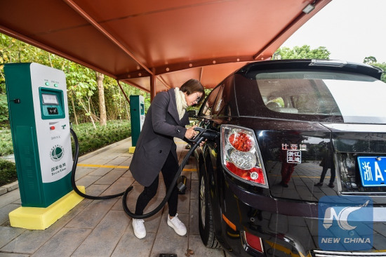 A driver charges the electric car at the Nanxun ancient town in Huzhou City, east China's Zhejiang Province, Nov. 10, 2016. Huzhou built electric vehicle chargers in some scenic areas to promote electric car. (Xinhua/Xu Yu)