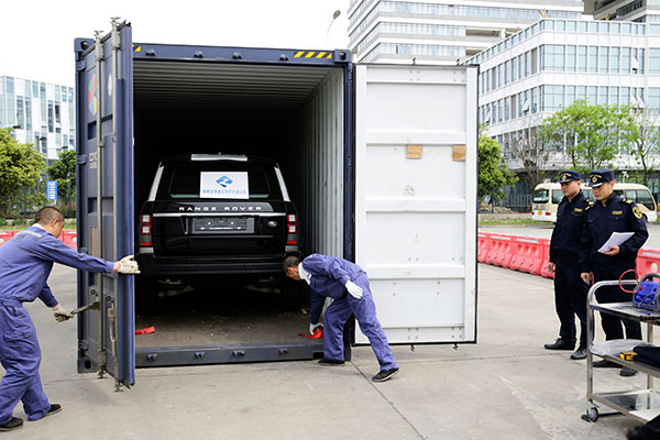 Workers unload a car at Chengdu inland port that was shipped from Nuremberg in Germany using a China Railway Express freight service. Chen Jian / For China Daily