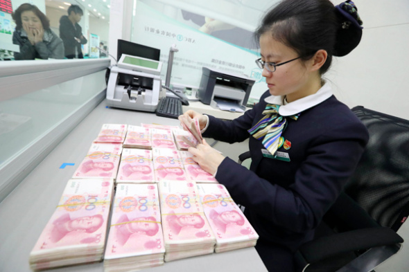 An employee counts yuan banknotes at a bank in Huaibei, Anhui province, Nov 25, 2016. (Photo: China Daily/Asianewsphoto.com)