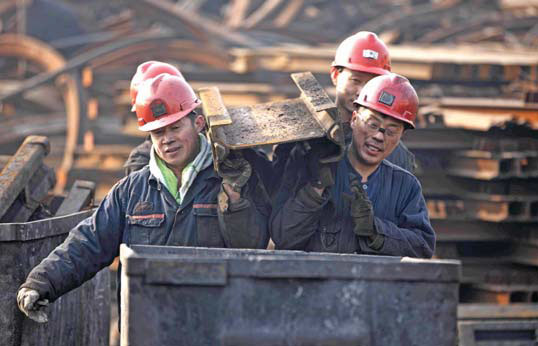 Miners carry parts at a colliery in Huaibei, Anhui province. Xie Zhengyi / For China Daily