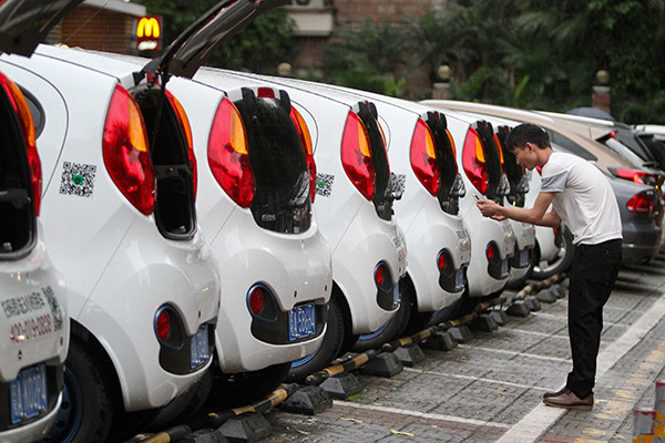 A customer in Guangzhou, Guangdong province, scans the code of Gofun shared cars from Shouqi Group. (Photo/China Daily)