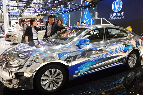 Visitors examine an autonomous driving car at an auto show in Beijing. (Photo/China Daily)