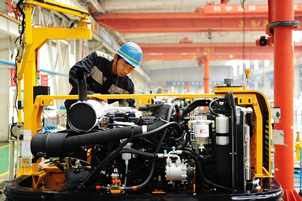 A worker assembles an excavator in a plant of Qingdao Lovol Excavator Co Ltd in Qingdao, Shandong province. (Photo/China Daily)