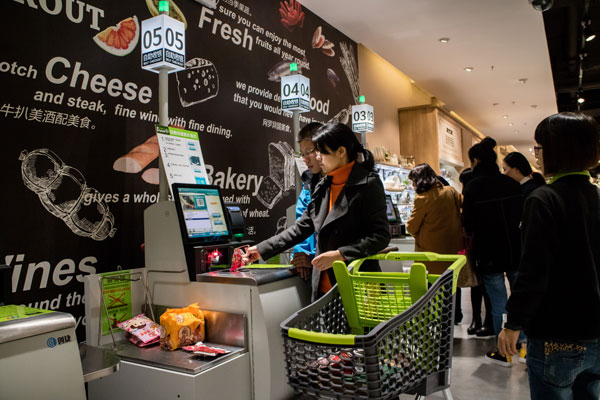 A woman uses the self-service machine to weigh the products in a Yonghui superstores in Fuzhou, Fujian. (Photo by Chen Hao/For China Daily)