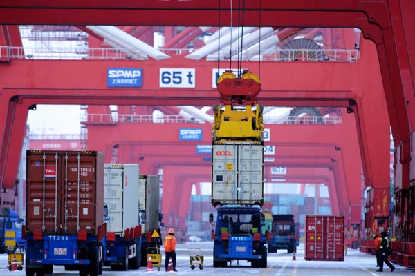 A ship loads containers at a terminal in Qingdao, Shandong province. (Photo/China Daily)