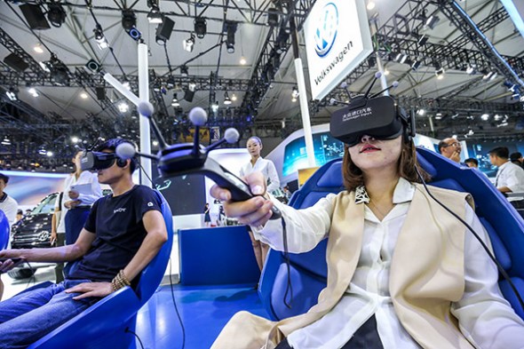 Visitors try out Touareg virtual reality experience technology at Volkswagen's booth at the Chengdu Motor Show 2017. (Photo provided to China Daily)