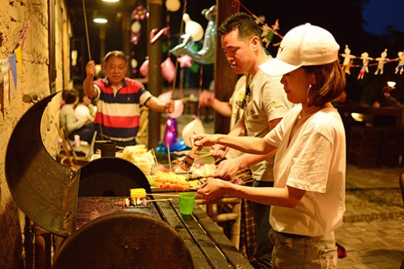 Tourists barbeque and make pizza in the open air kitchen of a B&B called Prodigy Outdoor Base in Moganshan of Zhejiang province. (A Yuan/for China Daily)