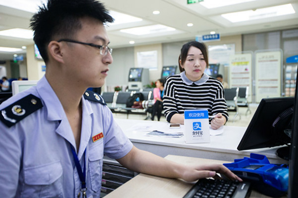 A public servant deals with a tax bill paid through Alipay in Xihu branch of the taxation bureau in Hangzhou, Zhejiang province. (Photo/China Daily)