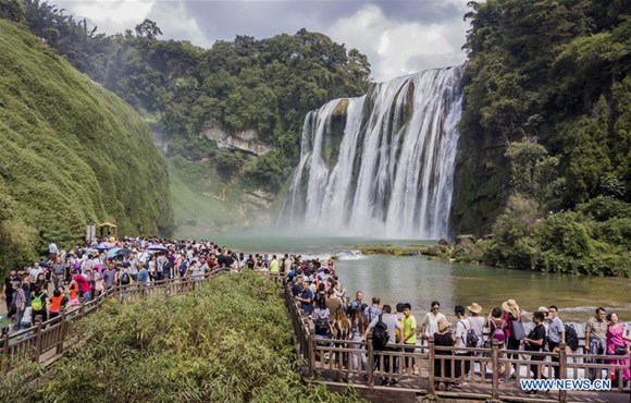 Tourists visit the Huangguoshu waterfall in Anshun City, southwest China's Guizhou Province, Oct. 2, 2017. From Oct. 1 to 8, the eight-day National Day and Mid-Autumn Festival holiday, around 710 million tourist trips will be made across China, according to predictions by China National Tourism Administration. (Xinhua/Chen Xi)