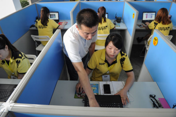 Dai Wenjian (center), founder of truck-calling app Huochebang, gives instructions to an employee at the company's office in Guiyang, Guizhou province. (Photo/Xinhua)