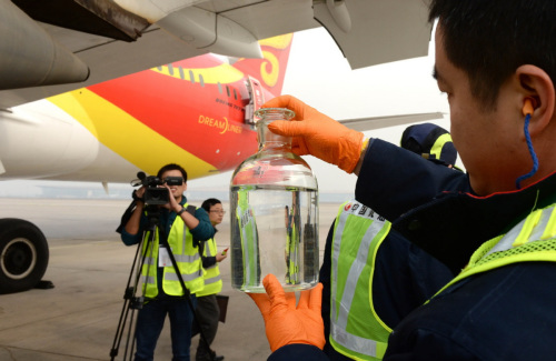 Hainan Airlines' ground staff display a biofuel that is used in aviation, in Beijing on Nov. 22, 2017. (Photo/Xinhua)