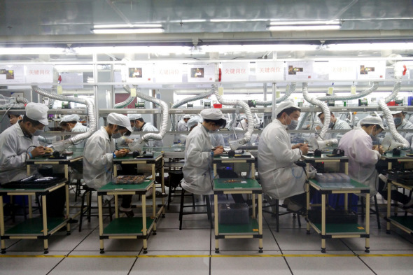 Employees of Foxconn Technology Group work at a production line of the company in Zhengzhou, capital of Henan province. (Photo provided to China Daily)