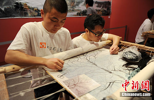 Two of the young artists are embroidering with hair.