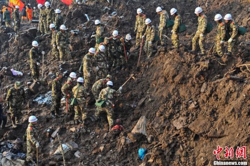 Rescuers work at the mud-inundated debris after a landslide hit Gaopo Village in Zhenxiong County, Southwest China's Yunnan Province, January 12, 2013. The death toll has risen to 46 as bodies of the last two missing were found Saturday morning. [Photo: CNS/Ren Dong]