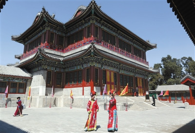 Two staffers who wear costume of Qing Dynasty are in Dehe Yuan (Garden of Virtue and Harmony). The Grand Theater Building in Dehe Yuan was open to public after restoration on Thursday.[Photo/The Beijing News]