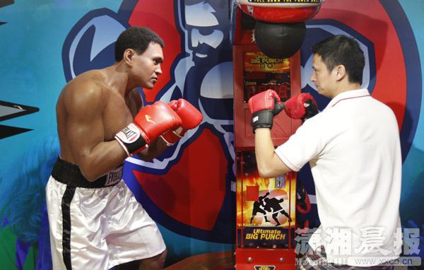 A visitor poses a fight with Muhammad Ali's statue.