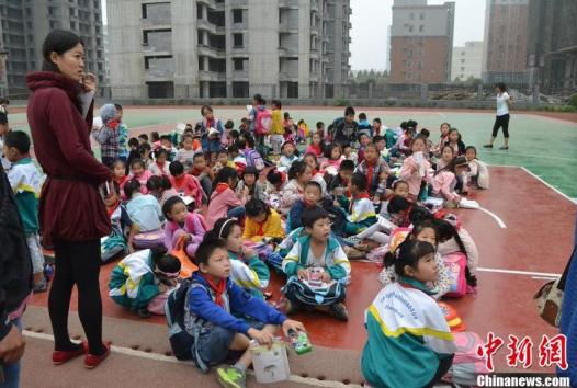 Pupils stay at the school basketball court after they are forced out of classrooms. (Photo source: CFP)