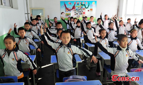 Students from Guangminglu Primary School in Shijiazhuang city of Hebei province practice some martial arts movements believed to be able to strengthen the body's resistance against smog, on Dec 11, 2013. School officials said certain movements could help lungs discharge harmful substances. 